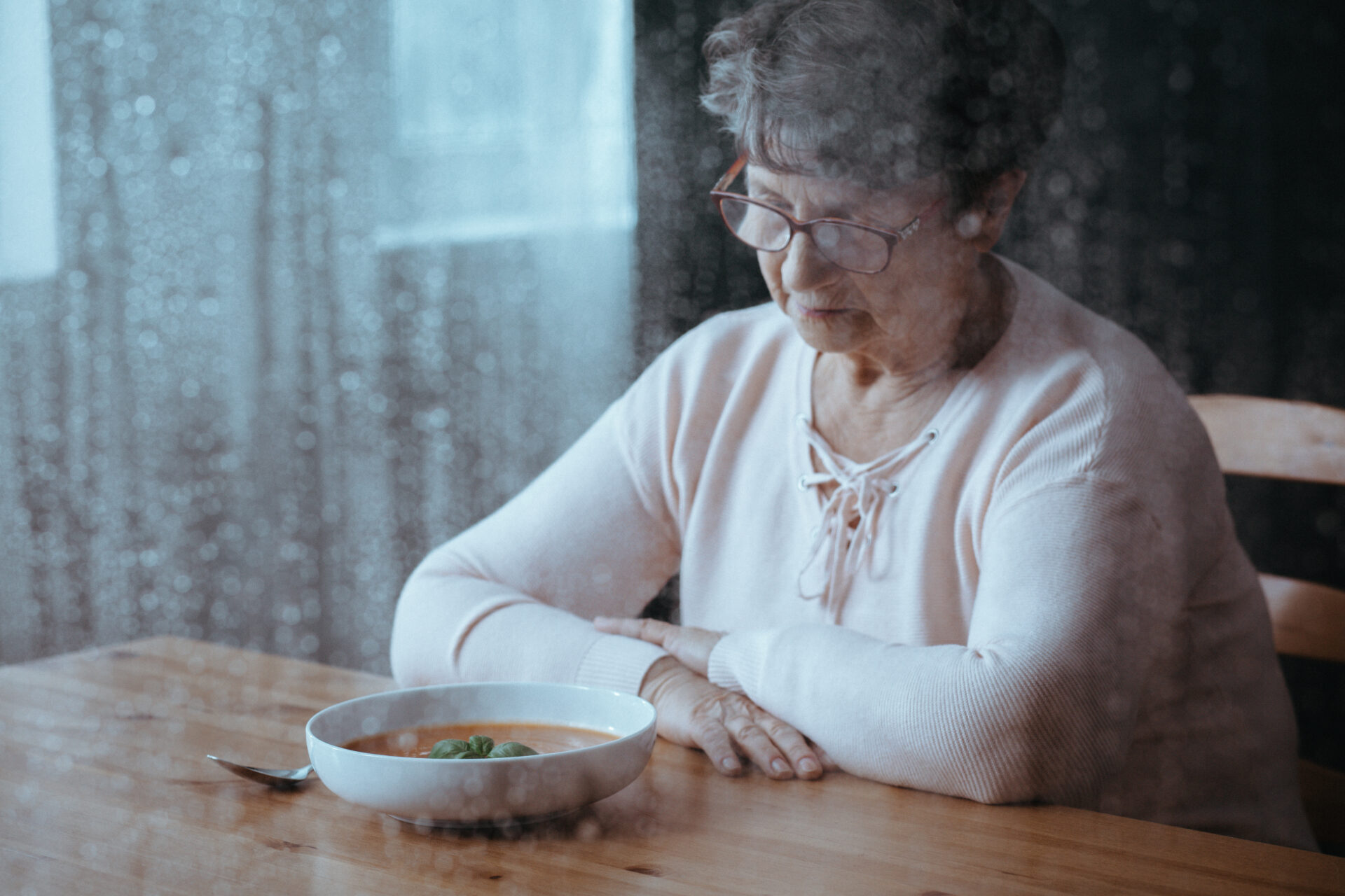 Sad, senior woman having lack of appetite