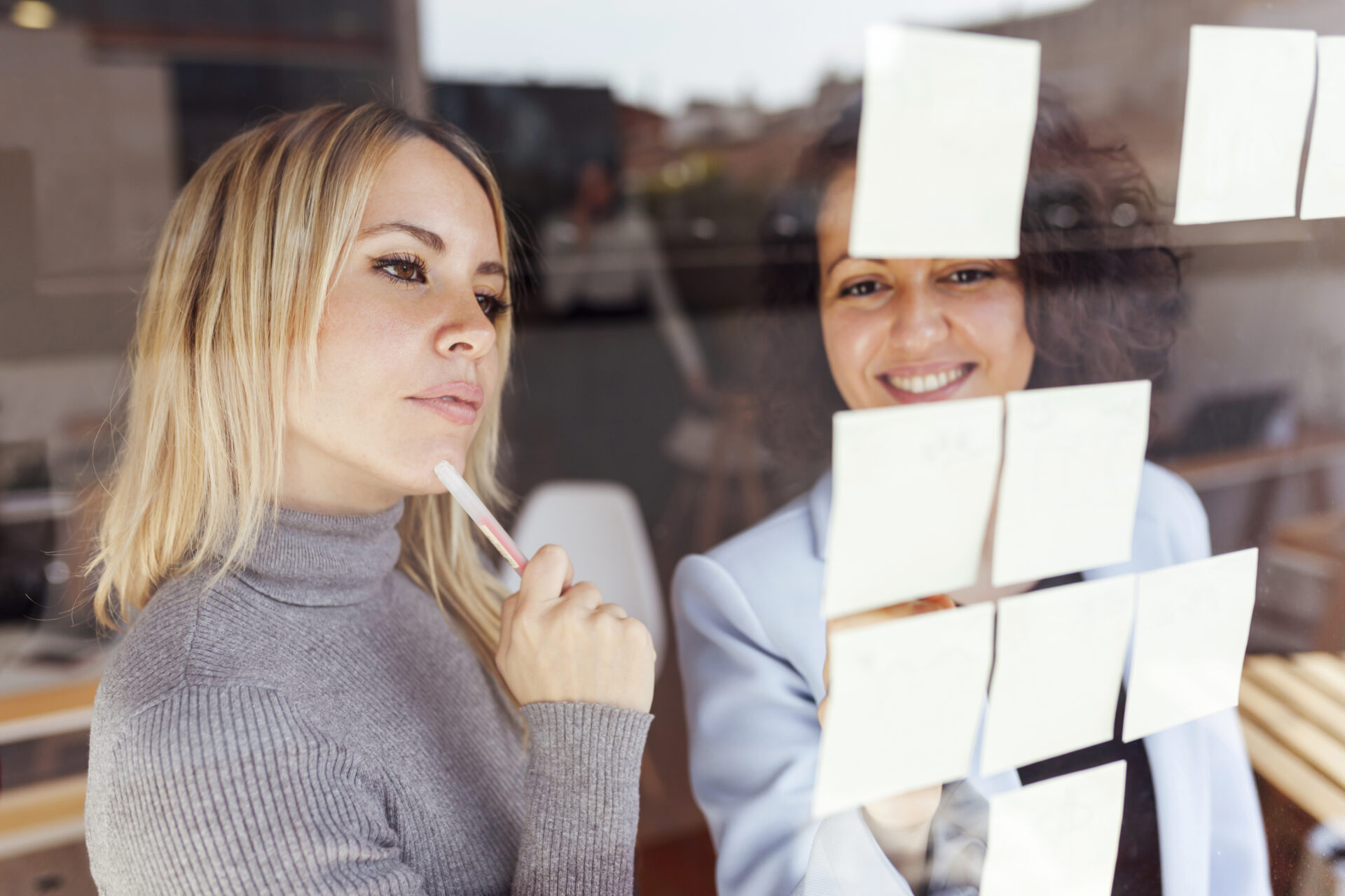 Care workers creating a plan and sticking sticky labels on a window during a supervision
