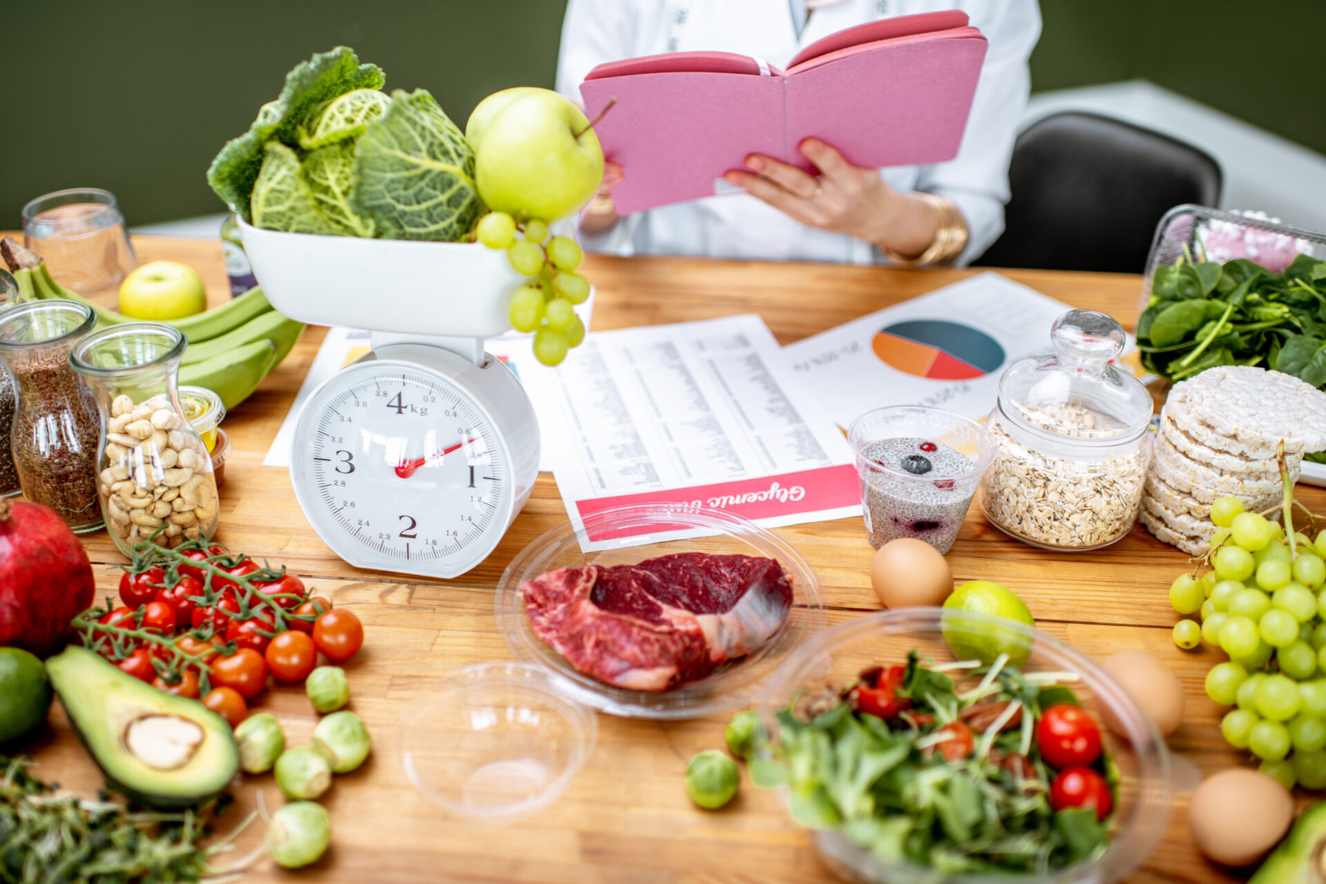 Woman dietitian working on a diet plan sitting with various healthy food ingredients, cropped image focused on food